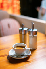 White cup of americano coffee and sugar bowl.