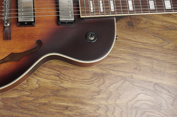 Jazz electro guitar on wooden texture background.