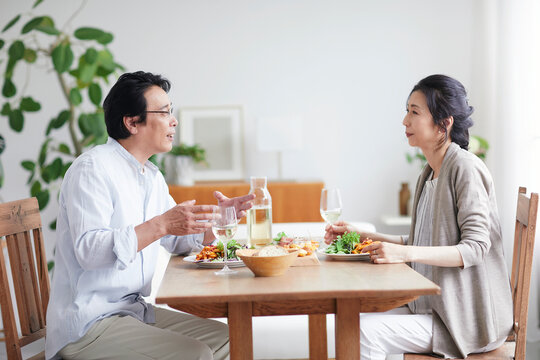 ワインを飲みながら食事をする夫婦