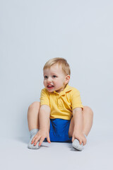 Little boy 3 years old in a yellow T-shirt and blue shorts, a boy in a sports uniform.