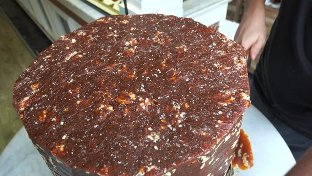 A candy maker slices cezerye, traditional Turkish candy made of carrot, sugar and coconat.  