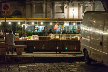 Person sitting at food stand outdoors