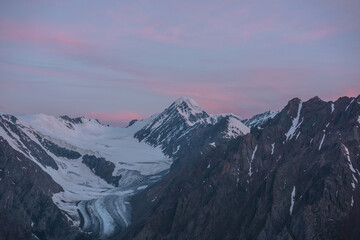 Scenic aerial view to high snow mountains in early morning in sunrise colors. Awesome scenery with...