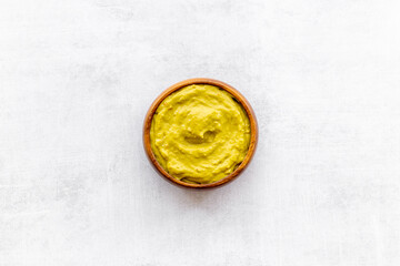 Green guacamole avocado dip in bowl, top view
