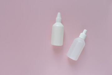 
two white medicine bottles on a pink background