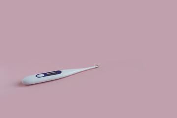 One digital thermometer on a pink background