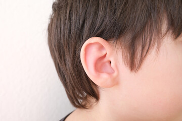 part of child's face in profile, a boy of 10 years old touches sore ear, concept of hearing organs...