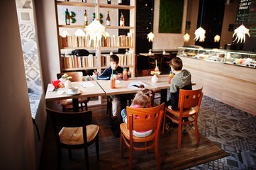 Kids sitting in cafe. Three children having rest.