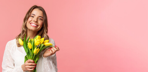 Spring, happiness and celebration concept. Close-up of lovely happy young blond girl in white...