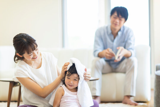 子供の髪をバスタオルで拭く母親