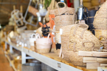 Wicker baskets and other handmade items on store shelves closeup