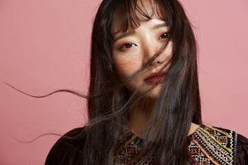 そばかすメイクをしたピンク背景の若い女性のポートレート