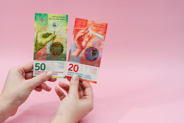Woman's hands holding euro banknotes on pink background. Money. Business