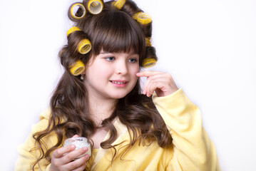 Portrait of little kid applying on facial cream