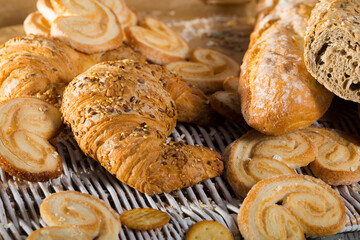 Assortment of fresh bread and bakery products lying on table .