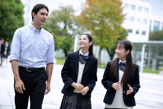 外国人と会話しながら歩く高校生