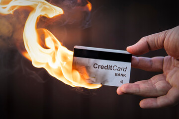 credit card in hand is on fire. Destruction of card payment. Termination of the validity of the...