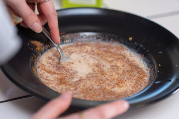 Making French toast. Mixing milk, egg and cinnamon in a bowl.