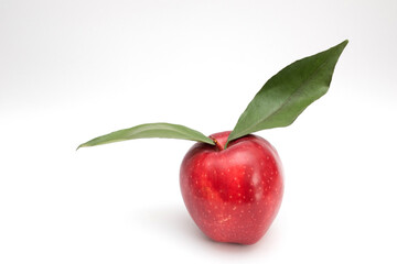 One Red apple with green leaves on a white background