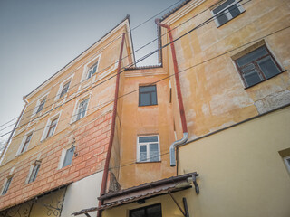 Fototapeta na wymiar Facade of an old faded orange townhouse, built in 19 century. Kamianets-Podilskyi, Ukraine.