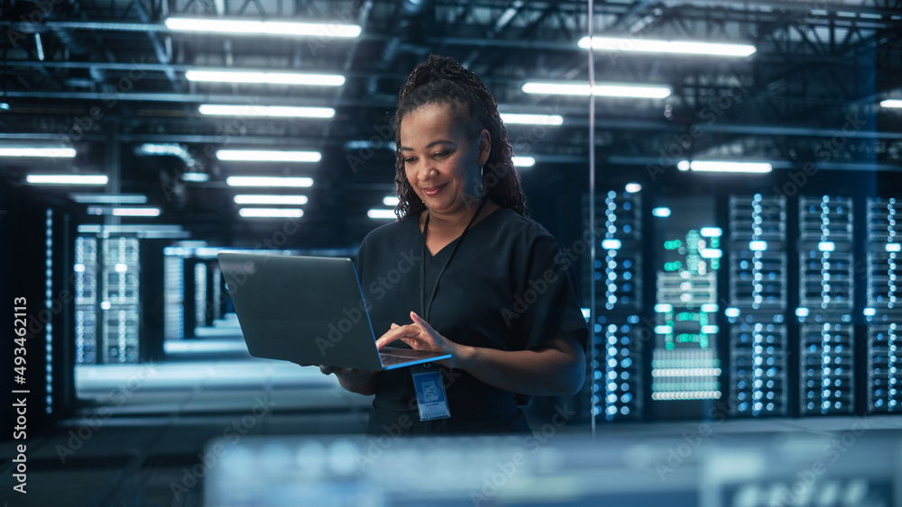 Leinwandbilder portrait of successful african american female it specialist using laptop, standing in data center. 