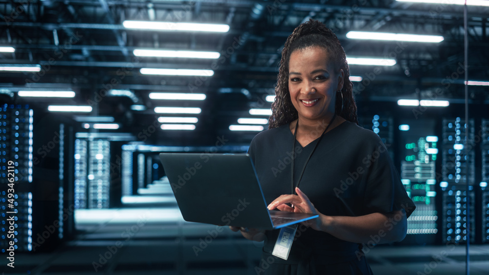 Aufkleber african american female it specialist using laptop computer, standing in big warehouse data center. 