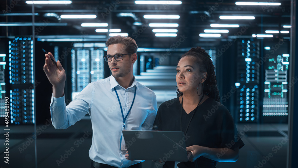 Fototapete Entrepreneur and IT Specialist Talk and Look at the Laptop in Diverse Big Data Center Server. Technical Support Scientist works with Cloud Infrastructure Architect. 