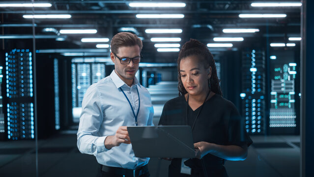 Mature Businesswoman Listens to Professional Advisor in Her Office, They Discuss Data Show on a Laptop. Smart Businesspeople Working in Finance. Specialists Work in Diverse Team. Big Data Concept - Powered by Adobe