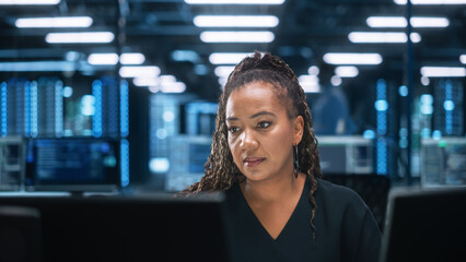 Successful African American Businesswoman Working on Computer in Big City Office Late in the...