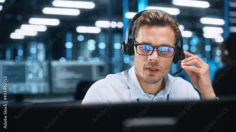 Poster Man Operator in Customer Support Service Center Talking with Client During the Evening. Male Using Computer And Speaking To Customer On The Call During Working At The Office