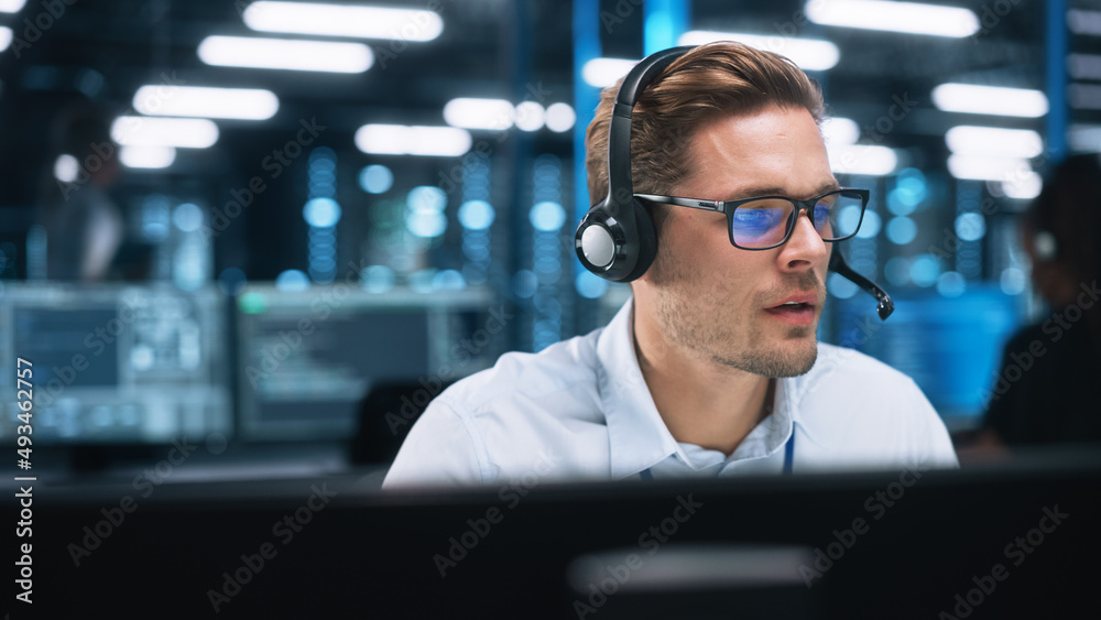Leinwandbilder Customer Service Operator at Work in Call Center. Caucasian Call Center Worker Talking with Customer in Modern Office at Night. Worker Speaking on Video Call on Computer Sitting at Table at Office