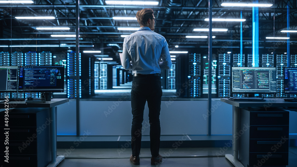 Poster Male Engineer Programs Something while Holding Tablet Computer in His Hands. He Works in a Dark Modern High-Tech Office. High-Speed Data Transfer and Smooth Server Operation, Analytics