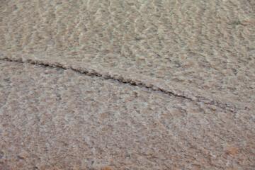 waves of crystals of salt on a bottom of the daed sea and somthing , looks like a long stick, covered by salt crystals