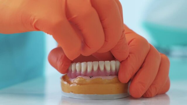 Close up video of implant dentures root, dentist working on denture.