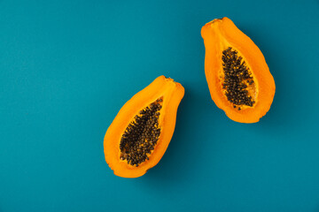 papaya fruit cutter on half on blue background