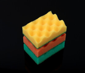 Multi-colored kitchen sponges on a black background. Sponge.