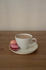 Pink sweet almond cookies with cream, a composition on a wooden table.