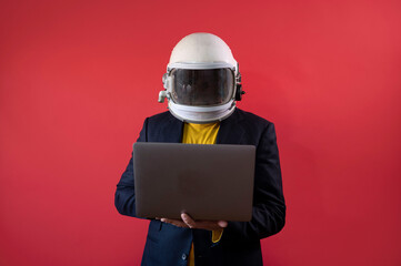 Businessman with astronaut helmet using a laptop © karrastock