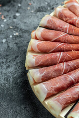 Italian prosciutto crudo or spanish jamon. Delicious appetiser Italian prosciutto and Spanish Iberian ham snack. vertical image. top view. place for text