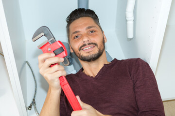 high angle view of man fixing sink pipe in kitchen