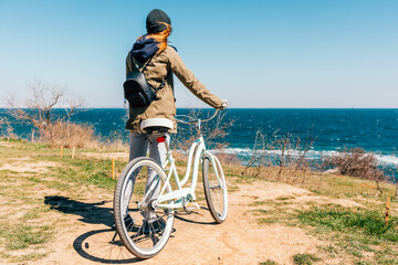 Fototapeta premium Rear view young woman holding her bike