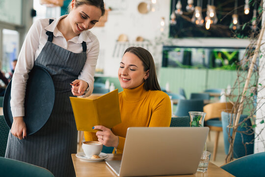 Woman Ordering Food In Restaurant