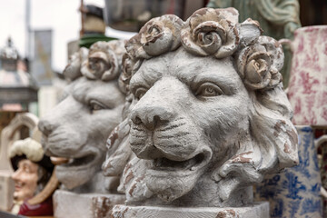 A pair of antique decorative lion head plant pots, with roses forming the mane.