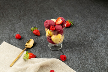 ice cream in bowl on the ground strawberries on black background