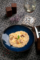 Risotto with porcini mushrooms, basil and olive oil on a plate. Italian Dish with rice and wild mushrooms with a glass of wine