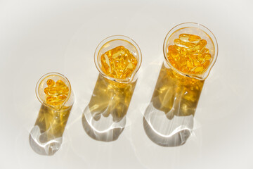 Fish oil gelatin capsules in laboratory transparent flasks on a white background.Healthy eating and...