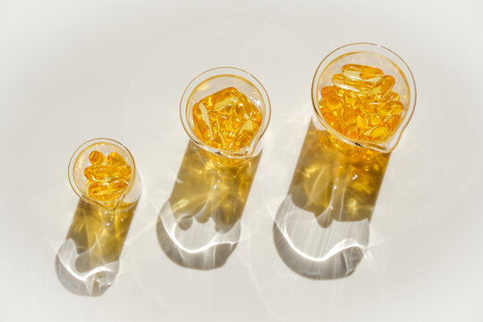 Fish oil gelatin capsules in laboratory transparent flasks on a white background.Healthy eating and food supplements.omega fatty acids. supplements and vitamin
