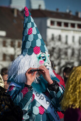 Basel - Switzerland - 9 March 2022 - portrait of masked people wearing traditional costume playing flute parading in the street © pixarno