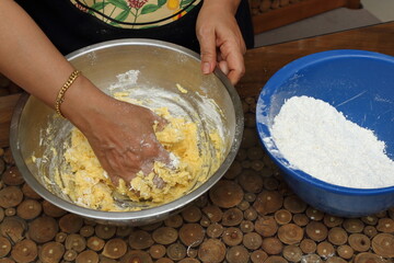 The lady's hand kneading the Kaasstengels (Dutch cheese finger cookies) dough