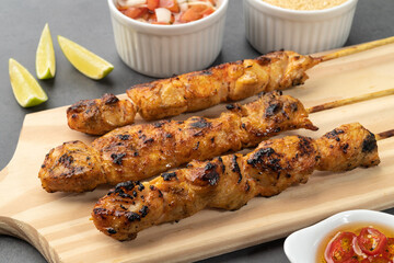 Chicken skewers over wooden board with farofa and vinaigrette